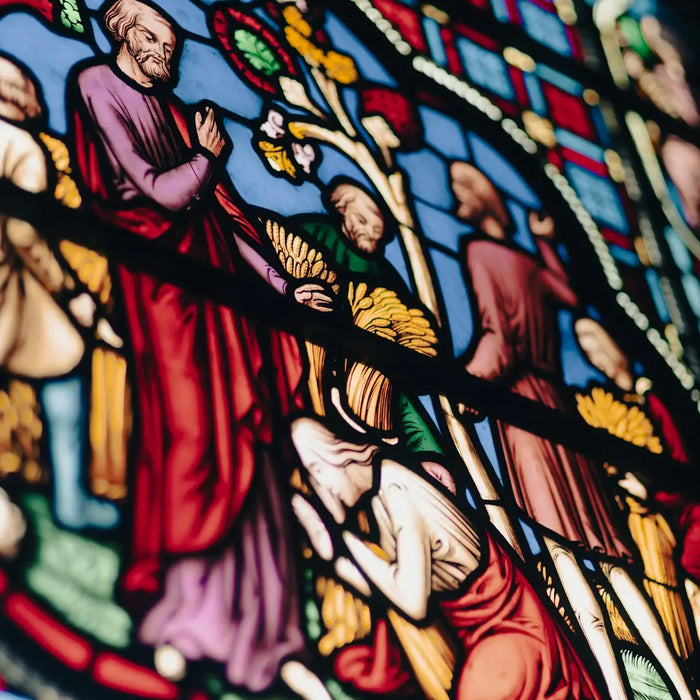 Stained glass window with religious figures enhances custom framing for modern memory.